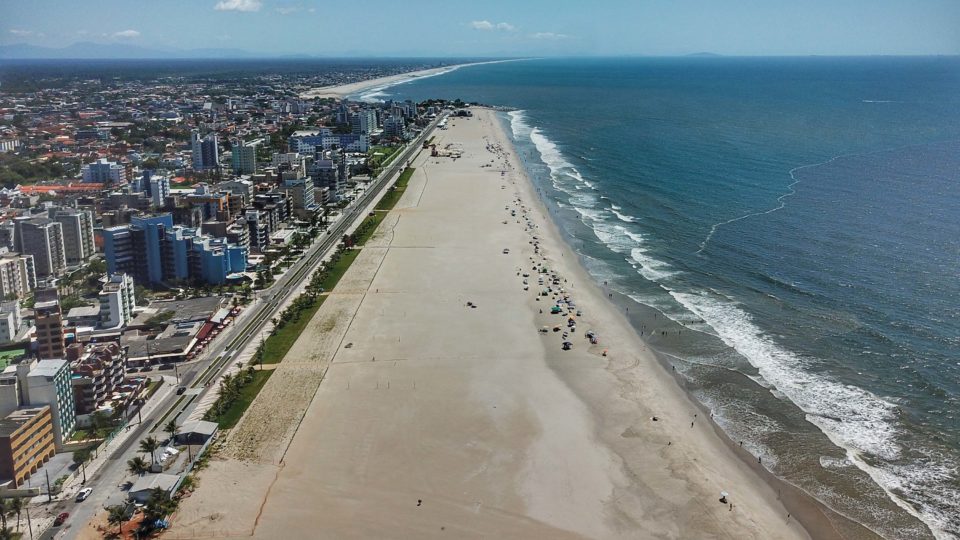 Vista aérea da orla de Matinhos com a praia, o mar e a cidade ao lado